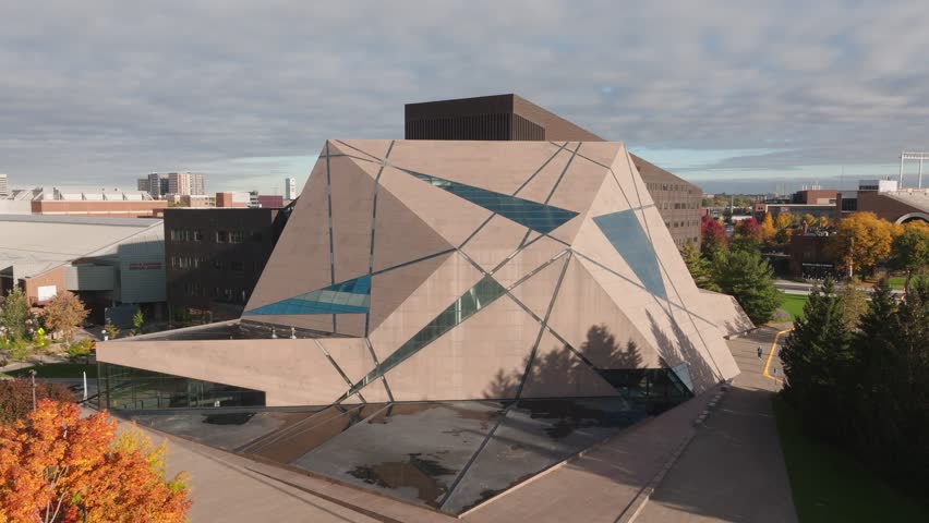 Aerial establishing shot of the McNamara Alumni Center at the University of Minnesota campus. Features the iconic geode architecture and pink granite exterior.
