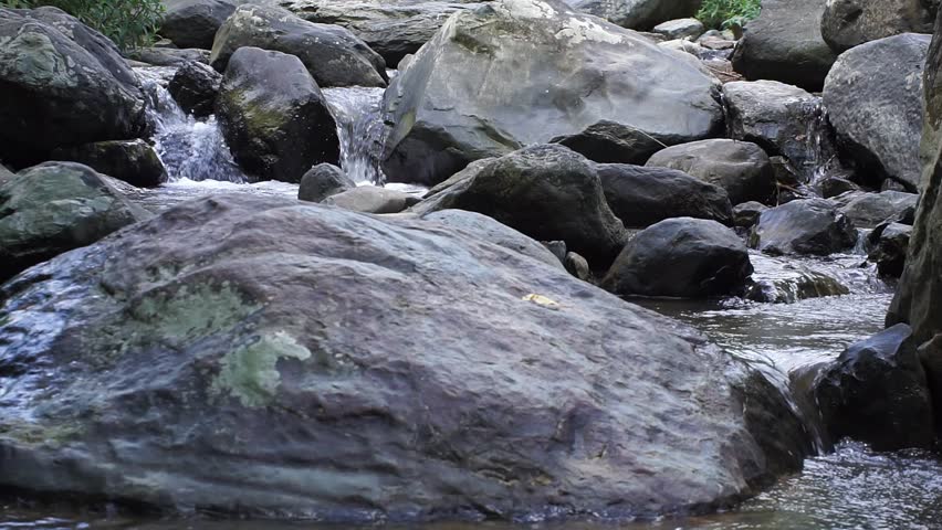 Structural composition of a shallow river bed showing the arrangement of different sized stones and how they affect the water flow direction