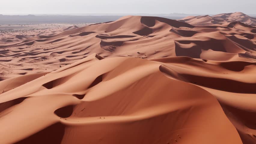 Side drone shot of big sandy dunes in morocco desert