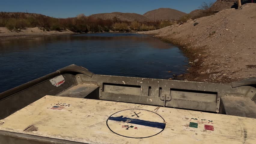 A rowboat ferry by the shore, crossing the Rio Grande between Boquillas, Mexico and Big Bend National Park, Texas on a sunny clear day