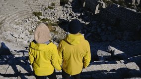 Young travelers discover ancient amphitheater and ruins of Termessos. Walking, climbing, enjoying view and ancient history in warm Turkish light. - Powered by Shutterstock - Get 15% off with code: PIKWIZARD15