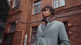 Joyful black guy chatting online in mobile app, portrait of man with smartphone. Townsman walking down city street in autumn or winter season, good mood and positive motion, cybersecurity in internet - Powered by Shutterstock - Get 15% off with code: PIKWIZARD15