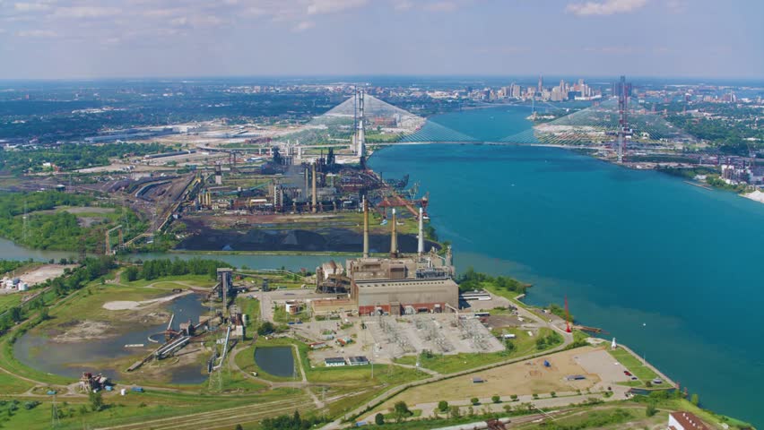 A high-resolution aerial view of the cable-stayed Gordie Howe International Bridge spanning the Detroit River, connecting Detroit, Michigan, USA, with Windsor, Ontario, Canada. This impressive modern 