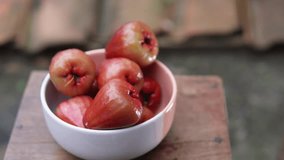 A person's hand taking a red water apple from a bowl. Fruit theme. Agriculture. - Powered by Shutterstock - Get 15% off with code: PIKWIZARD15