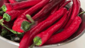 Slow-motion close up video of Red Mexico or Chili peppers being washed under a faucet against a white background. This footage emphasizes the vibrant colors and textures. Food and cooking concept. - Powered by Shutterstock - Get 15% off with code: PIKWIZARD15