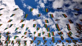 Colorful LGBTQIA plus pride flags waving in slow motion against a beautiful blue sky with white clouds, representing freedom, diversity, equality, and the gay and lesbian community - Powered by Shutterstock - Get 15% off with code: PIKWIZARD15