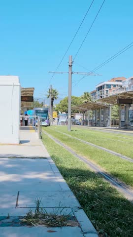 Modern Tram Arriving at Station on Grass Track (Turkey, İzmir, Karşıyaka, Bostanlı)
