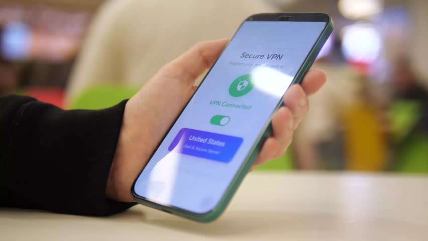 A tech savvy individual takes control of her online privacy by enabling a VPN connection on her device in a crowded mall. This video represents empowerment in the digital age, ensuring freedom and