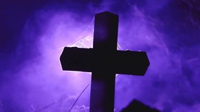 A dark cross silhouetted against eerie purple fog, with delicate spider webs visible around the edges, creating a moody, mystical atmosphere. - Powered by Shutterstock - Get 15% off with code: PIKWIZARD15