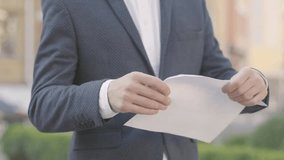 A well-dressed businessman in glasses tears documents in an office, symbolizing workplace stress, business challenges, frustration, and the pressures of professional life. - Powered by Shutterstock - Get 15% off with code: PIKWIZARD15