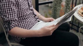 A man reads a newspaper on a balcony overlooking the city, enjoying a quiet moment in the morning, blending urban lifestyle, relaxation, and daily routine with scenic city views. - Powered by Shutterstock - Get 15% off with code: PIKWIZARD15