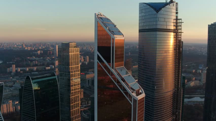 Aerial view of Moscow City skyscrapers glowing in the warm evening sun, showcasing modern architecture, corporate towers, and the dynamic skyline of Russia’s capital.