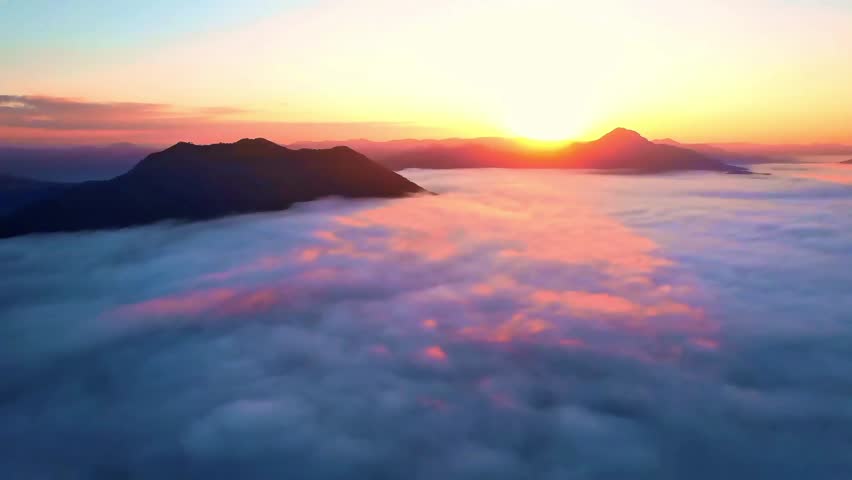 Majestic sunrise above a sea of clouds and mountain peaks creating a stunning golden landscape
