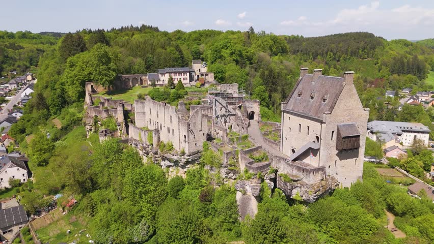 larochette castle restoration progress outer walls green cover cloudy hazy sky beautiful town below luxembourg close forward drone shot view château fort de