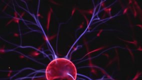 Glowing plasma filaments stretch from the center of a plasma ball, emitting vibrant purple and red electric arcs against a dark background. - Powered by Shutterstock - Get 15% off with code: PIKWIZARD15
