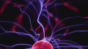 Glowing plasma filaments stretch from the center of a plasma ball, emitting vibrant purple and red electric arcs against a dark background. - Powered by Shutterstock - Get 15% off with code: PIKWIZARD15