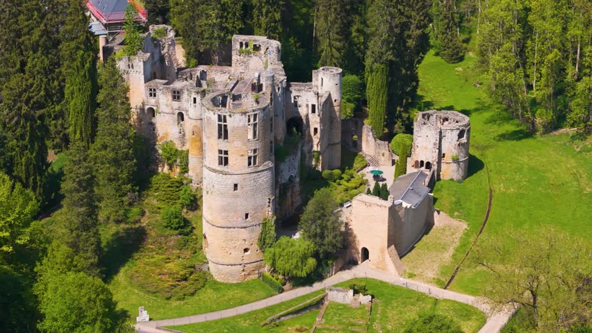 medieval castle beaufort’s outer walls ruins green gardens below beaufort luxembourg to left right drone panning les châteaux de fortress grounds