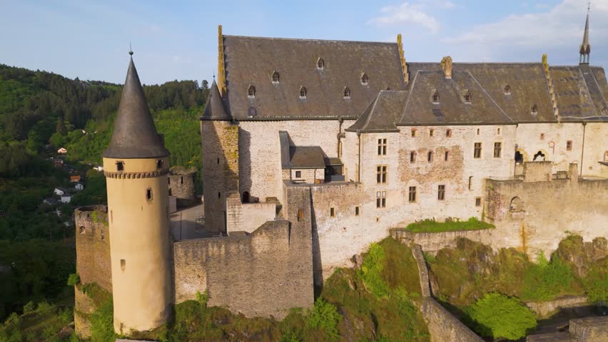 vianden castle chateau de historical site green hills cloudy sky town homes cars upper area old windows to from left near right closeup drone panning shot luxembourg