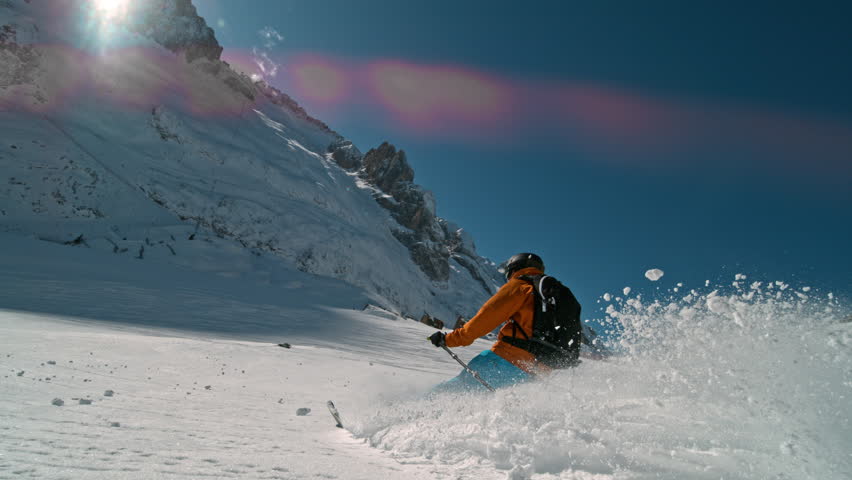 Skier riding in the scenic Dolomites mountains in fresh powder snow. Super slow motion at 1000 fps.