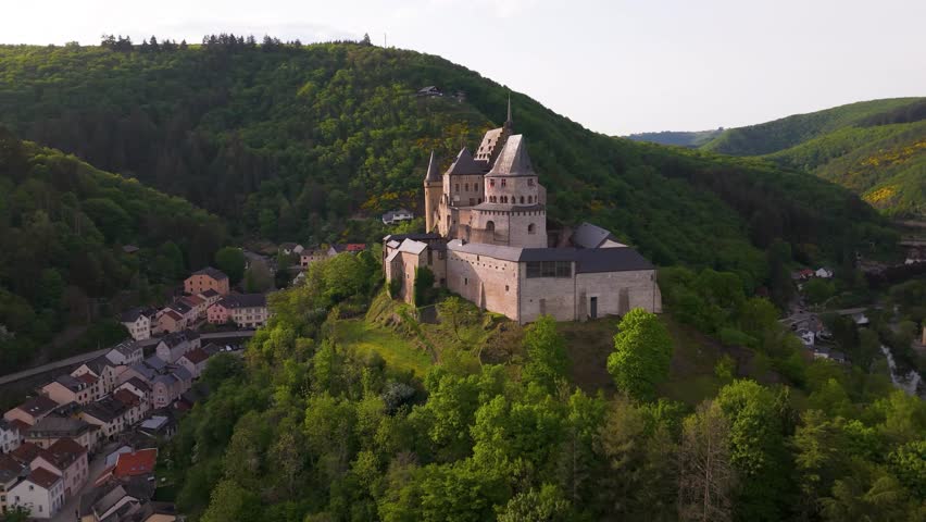 vianden castle chateau de surrounded by green cover hills cloudy sky beautiful homes below upper area highlight to from left near right afar circling drone luxembourg