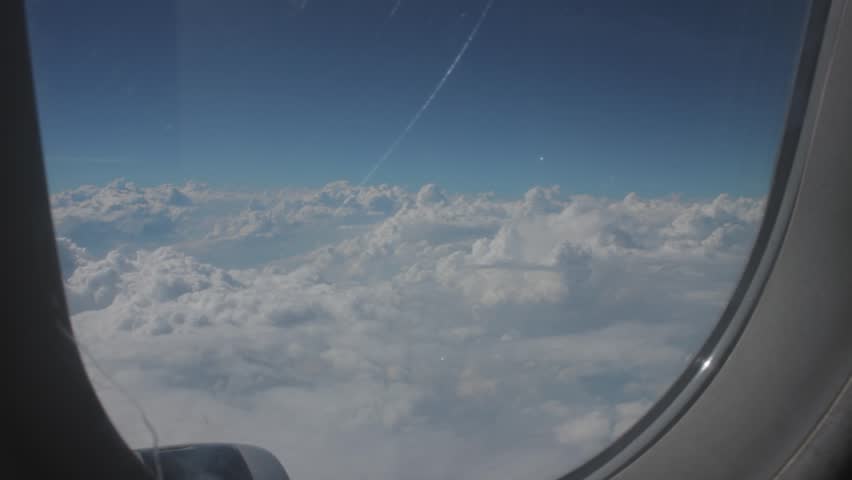 View from airplane of clouds and blue sky during flight