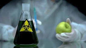 Scientist Injecting Apple Beside Toxic Biohazard Flask - Powered by Shutterstock - Get 15% off with code: PIKWIZARD15