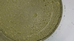 A mesmerizing, extreme close-up, top-down view of a thick, yellowish liquid filled with numerous small and large bubbles, suggesting foam, carbonation, a chemical reaction, or oil mixed with water - Powered by Shutterstock - Get 15% off with code: PIKWIZARD15