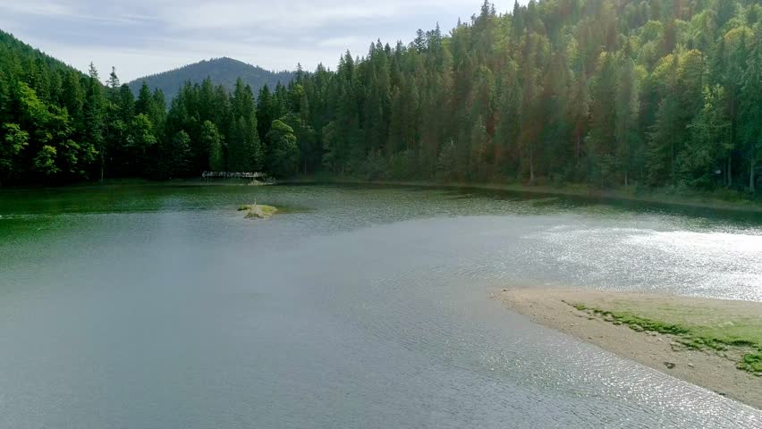 Transparent lake and around nice green forest, transparent lake surrounded by nice green forest creates pristine natural landscape. clear reflections and serene atmosphere ideal for purity themes