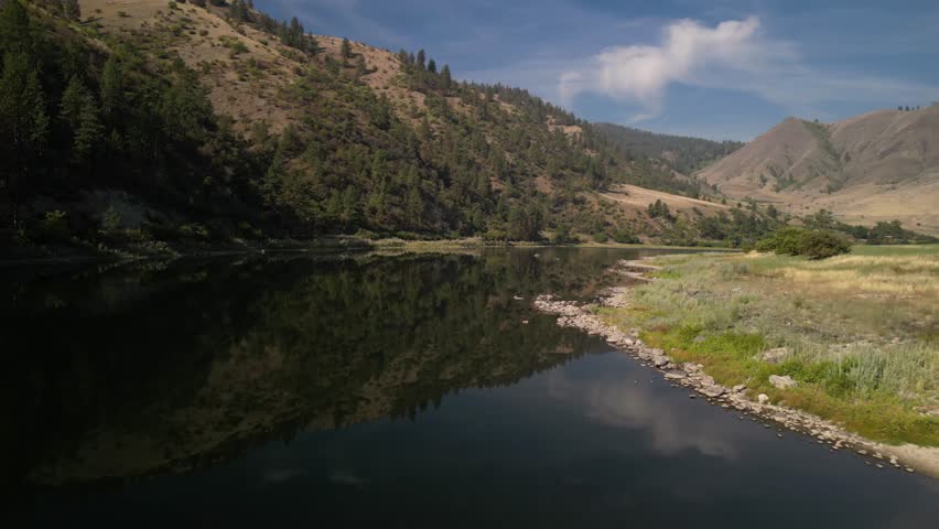 Aerial above calm and glassy Salmon River in White Bird Idaho on sunny day