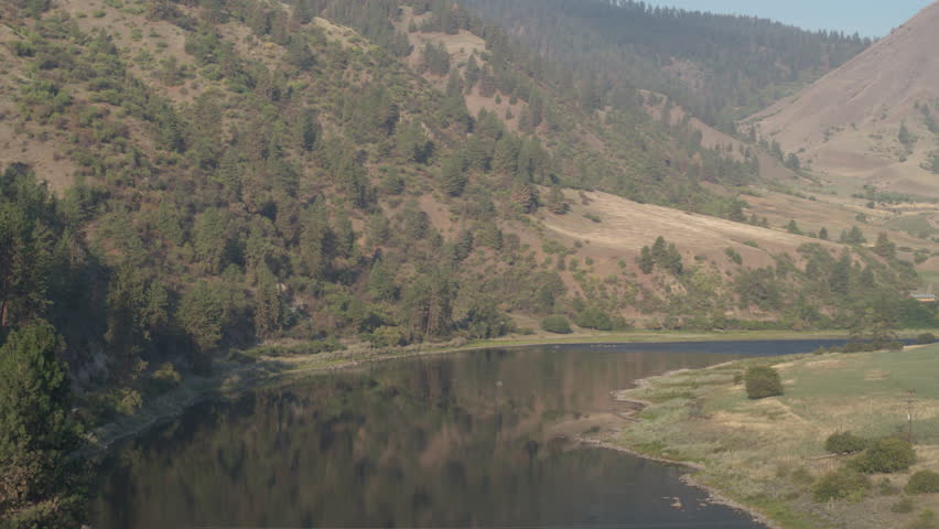 Aerial above peaceful and calm Salmon River on hazy day in White Bird Idaho