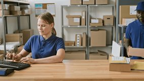 Medium portrait of Caucasian female courier delivery office representative working on computer, African American male associate carrying package for shipment, both looking at camera, smiling - Powered by Shutterstock - Get 15% off with code: PIKWIZARD15
