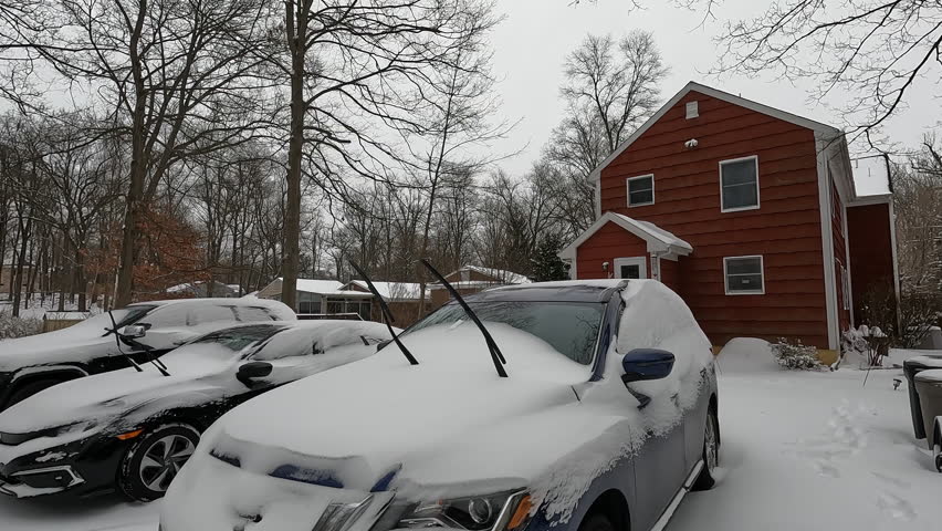 backyard cars and house covered with snow in January with snow drifts