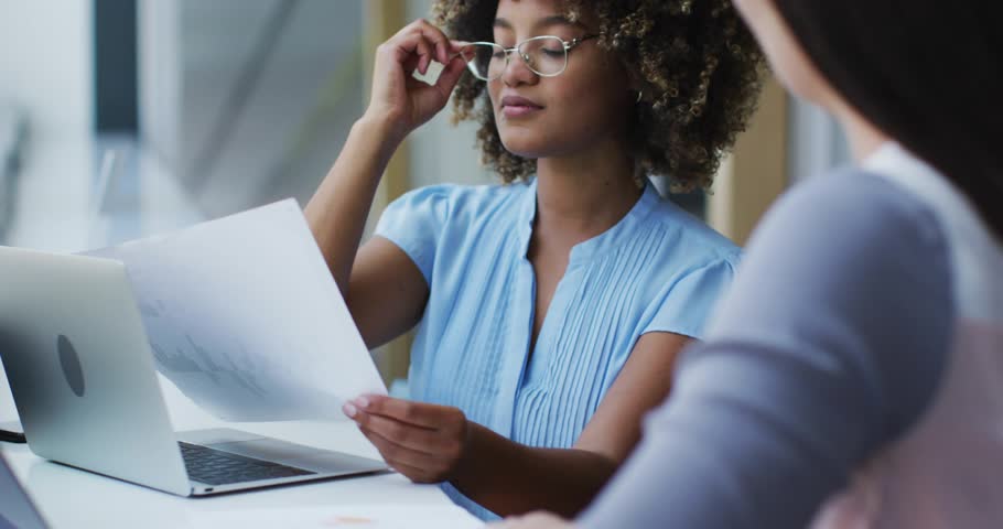 Woman presenting business report, adjusting specs and starting animated data overlay showing growth. Duo, meeting, laptop, glasses, documents, visualization, analytics