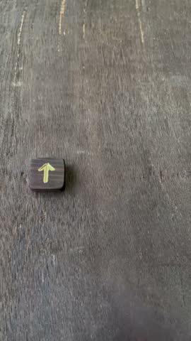 A female hand placing three handcraft wooden Runes in sequence of Thurisaz, Gebo, and Kenaz. Displaying spread for Divination on a grainy wooden surface.
