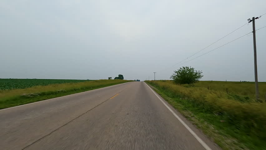 Idyllic views of rural life driving through the countryside on a rural road surrounded by agricultural fields. Located in the heart of Illinois Amish country - Arthur, Illinois.