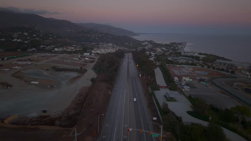 Cars Driving on Pacific Coast Highway and the coastal mountains behind. Looking South towards Downtown Malibu, Santa Monica and Long Beach California