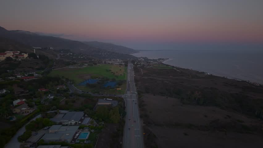 Cars Driving on Pacific Coast Highway and the coastal mountains behind. Looking South towards Downtown Malibu, Santa Monica and Long Beach California. Pepperdine University area.