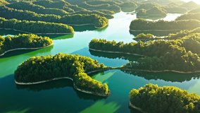 Aerial shot of a beautiful turquoise lake with numerous green forest islands and rolling hills at golden sunrise  - Powered by Shutterstock - Get 15% off with code: PIKWIZARD15