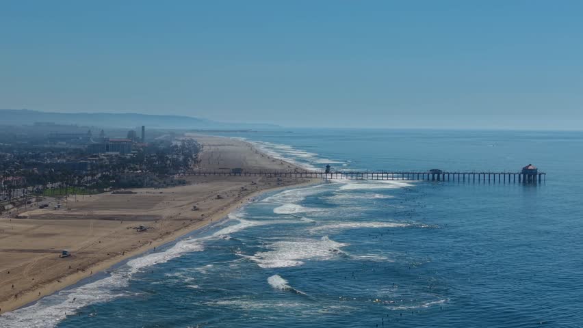 Coastal view of Huntington Beach Pier, Orange County California, wide aerial Landscape looking south toward Newport and Laguna. Pacific West Coast, surfing waves, sandy beaches, sunny summer day