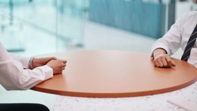 Two Business Professionals Sitting At A Round Table In A Modern Office Meeting Room With Their Hands Resting, Real-time Footage With Natural Light. - Powered by Shutterstock - Get 15% off with code: PIKWIZARD15