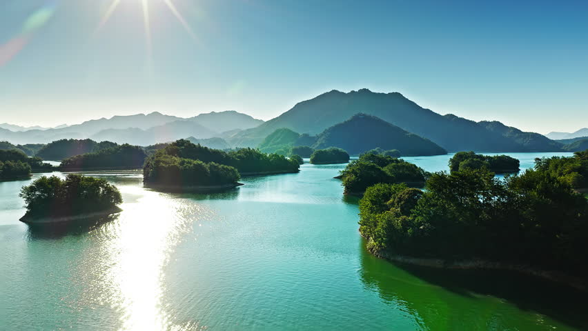 Aerial shot of a beautiful blue lake with green forest islands and mountain natural landscape in the morning. Famous Qiandao Lake scenery in Hangzhou, China.