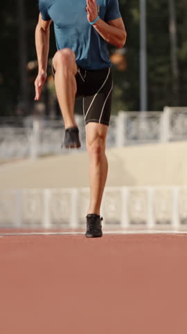 athlete runner sprinting on stadium track vertical slow motion fullHD speed energy discipline strength determination performance focus movement healthy lifestyle motivation