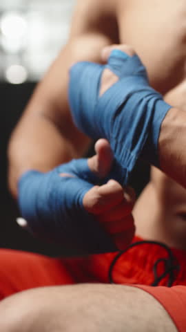 Powerful Male Fighter Wrapping Blue Hand Bandages Before Combat Symbol Of Determination Strength And Focus Preparation Ritual Of Martial Artist In Gym Before Kickboxing Training Fight Concept Of
