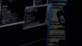 Anonymous hacker using a computer in a dark room, symbolizing cybercrime, data breaches, cybersecurity threats, and digital anonymity. - Powered by Shutterstock - Get 15% off with code: PIKWIZARD15