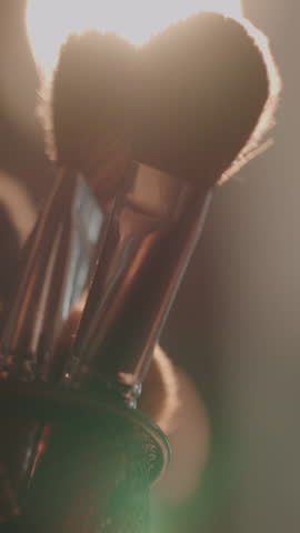 makeup brushes illuminated by cinematic studio light beauty tools detail in warm glow fashion industry aesthetic natural glam look professional makeup artistry backstage creative light setup slow