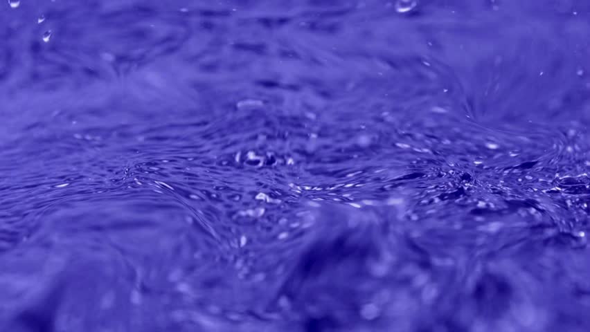 Tiny droplets and intricate ripples create a mesmerizing pattern, with soft bokeh highlights adding depth and ethereal beauty.