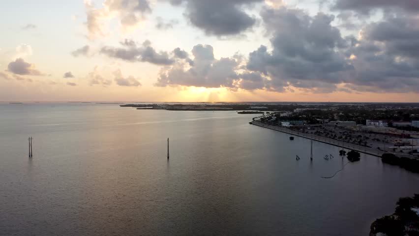 Panoramic aerial drone shot over Key West, Florida at sunrise, capturing the Salt Pond Keys near Dredgers Key and Sigsbee Road as golden morning light reflects across calm tropical waters.