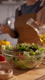 Clean eating lifestyle woman pouring olive oil on organic green salad slow motion vertical clip home chef cooking healthy fats concept mindful nutrition homemade - Powered by Shutterstock - Get 15% off with code: PIKWIZARD15
