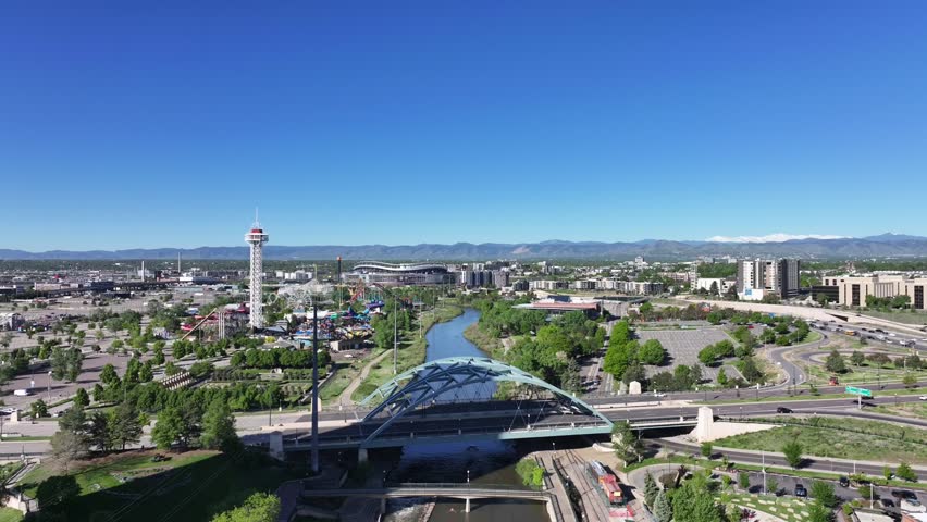 Aerial view of Denver over the South Platte River as the drone flies forward on a clear sunny day.