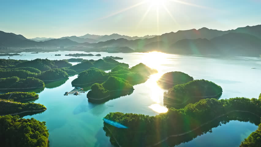 Aerial shot of a beautiful blue lake with green forest islands and mountain natural landscape in the morning. Famous Qiandao Lake scenery in Hangzhou.